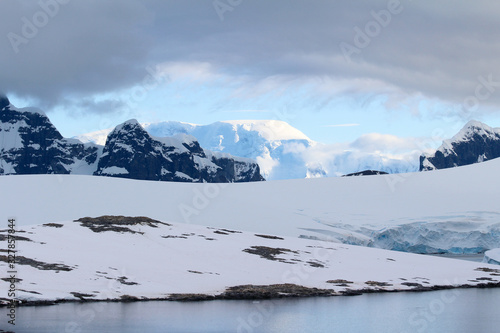 Snow-capped mountains and frozen coasts at Dorian Bay on the northwest side of Wiencke Island, Palmer Archipelago, Antarctica