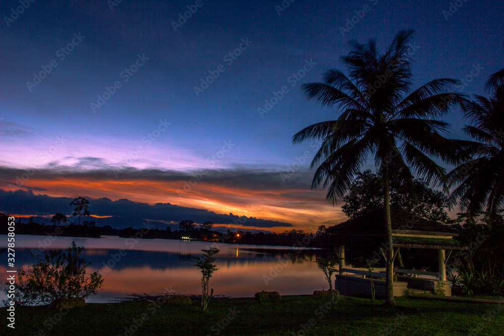 Wallpaper blurred nature of the twilight light in the evening by the large water basin surrounded by big trees, the integrity of the forest Wallpaper blurred nature of the twilight light in the evening by the large water basin surrounded by big trees, the integrity of the forest