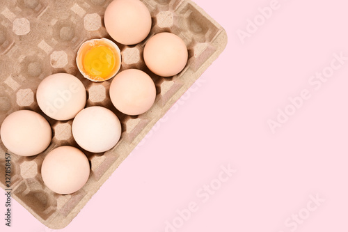 natural homemade eggs in a tray. A tray of eggs on a white and pink background. eco tray with testicles. minimalistic trend, top view. Egg tray. Easter concept.