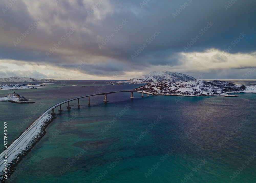 drone view of Sommaroy bridge in Norway and the snowstorm in the distance which clouded the sky and the transparent turquoise water
