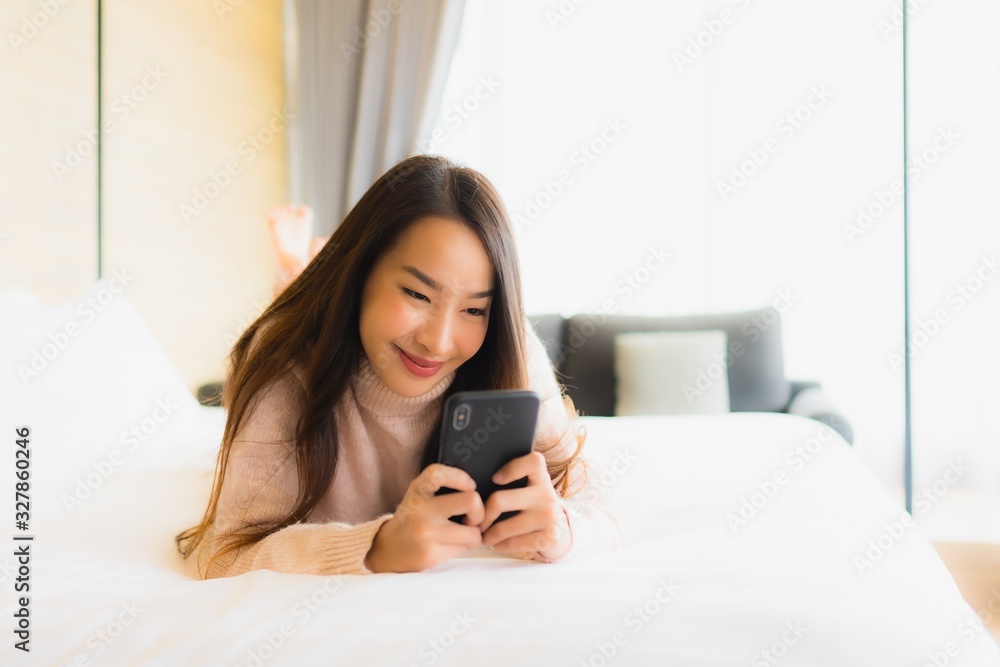 Portrait beautiful young asian woman with coffee cup and mobile phone on bed Portrait beautiful young asian woman with coffee cup and mobile phone on bed