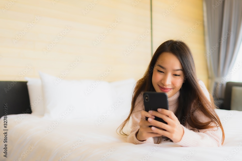 Portrait beautiful young asian woman with coffee cup and mobile phone on bed Portrait beautiful young asian woman with coffee cup and mobile phone on bed