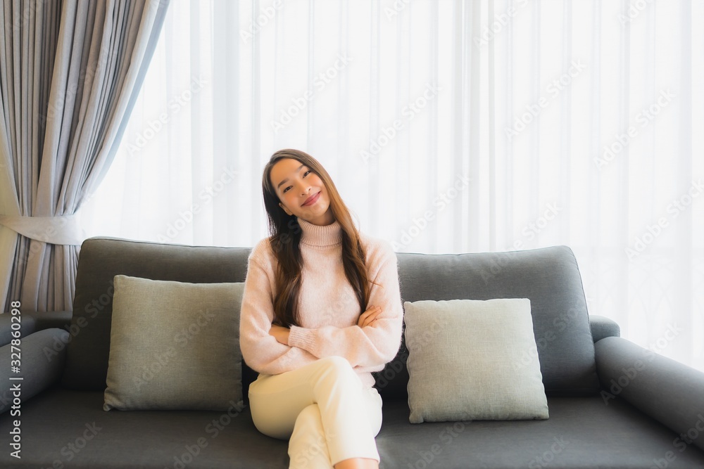 Portrait beautiful young asian woman sit on sofa chair for relax in living room Portrait beautiful young asian woman sit on sofa chair for relax in living room