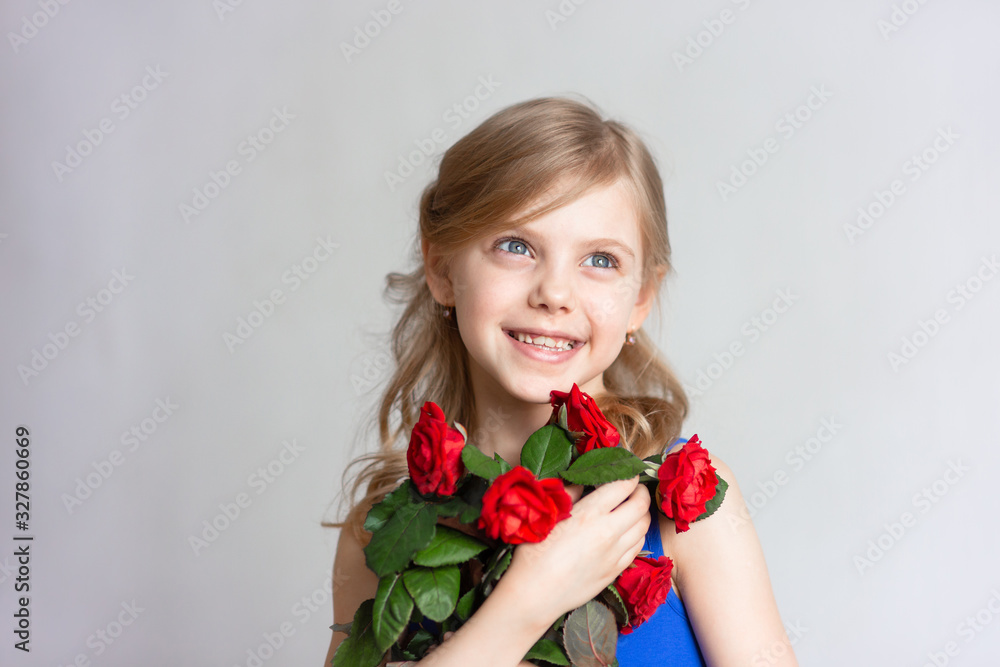 cute child 7-8 years old, mother's daughter, pretty little girl, girl with blond hair, with red roses gifted on women's day cute child 7-8 years old, mother's daughter, pretty little girl, girl with blond hair, with red roses gifted on women's day