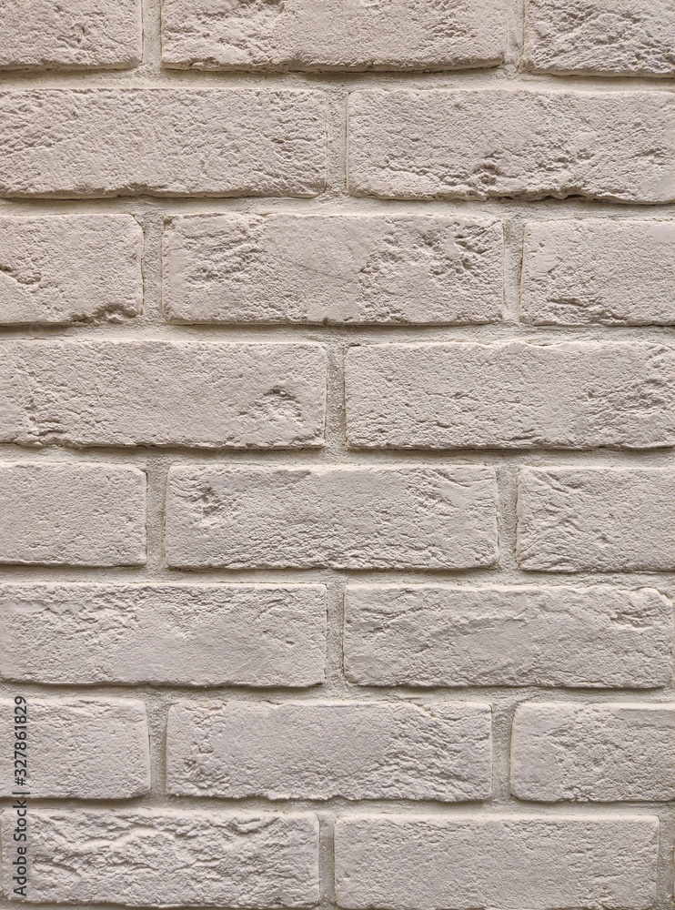 The background of the wall is a light-colored brick surface. The texture of the brick. Abstract wall background. The background of the wall is a light-colored brick surface. The texture of the brick. Abstract wall background.