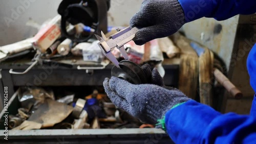 Hand close-up of a mechanic to use vernier caliper for measurement scale of a pulley