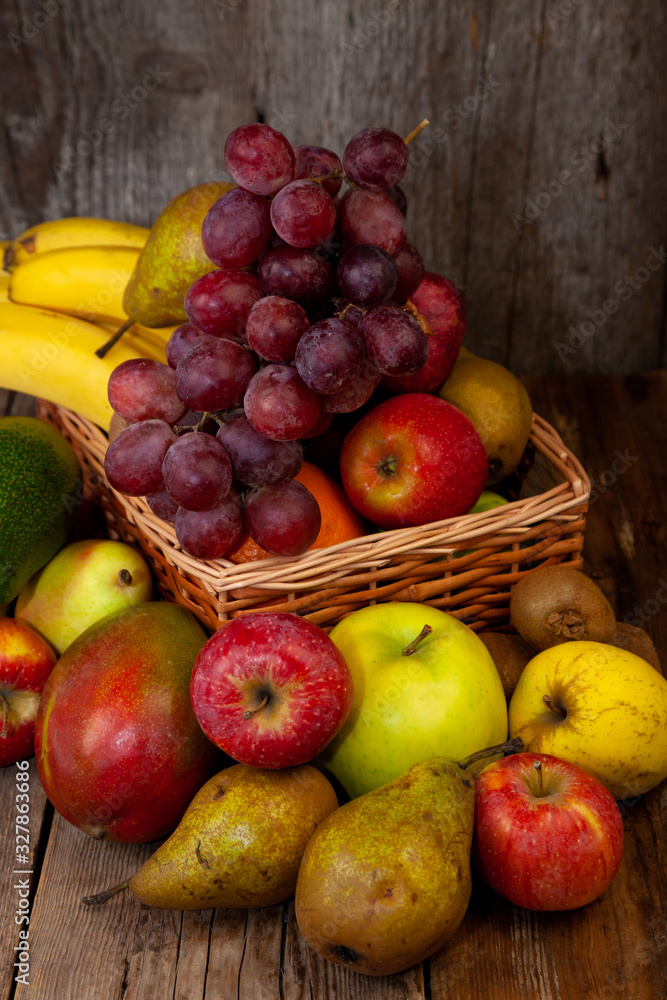 Fruit basket with place for text. Set of different fruits on a wooden kitchen table. Vitamin nutrition, healthy food. Red grapes, blueberries, mangoes, orange, apple, kiwi. Fruit basket with place for text. Set of different fruits on a wooden kitchen table. Vitamin nutrition, healthy food. Red grapes, blueberries, mangoes, orange, apple, kiwi.