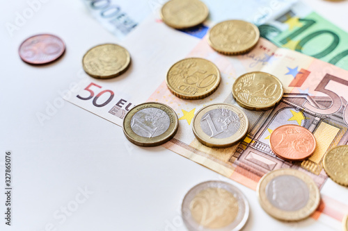Calculation of expenses. Close up of one euro coin surrounded by different coins and 100 and 50 Euro banknotes. Copy space for your text
