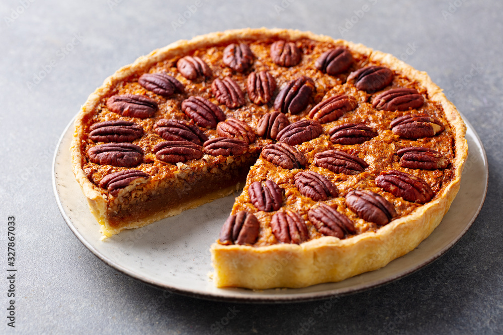 Pecan nut pie, tart on a plate. Grey background. Close up. Pecan nut pie, tart on a plate. Grey background. Close up.