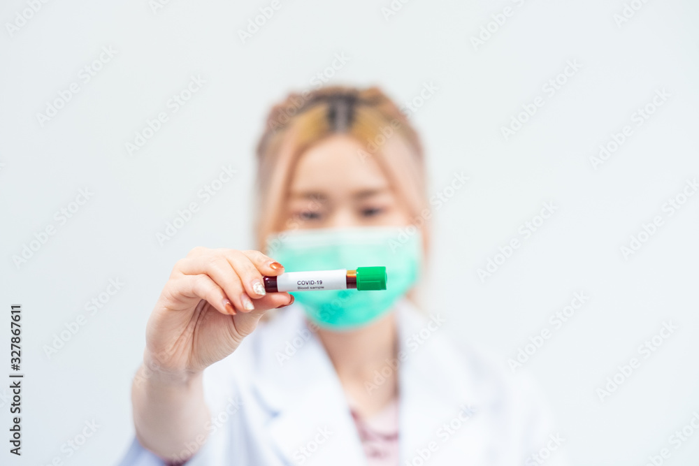 Asian male doctor holding Covid-19 Blood Sample on White Background Asian male doctor holding Covid-19 Blood Sample on White Background