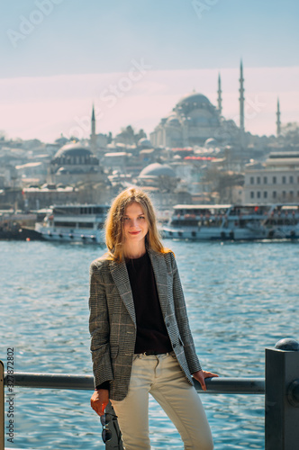 Photography Beautiful girl with blond hair stands on embankment of Istanbul with view to Sul