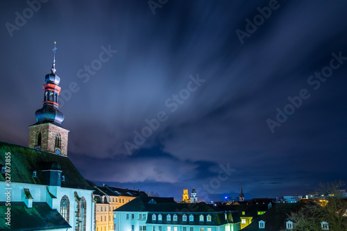 Germany, Magical night sky over roofs and skyline of saarbruecken city at schlosskirche church by night with view to ludwigskirche photo