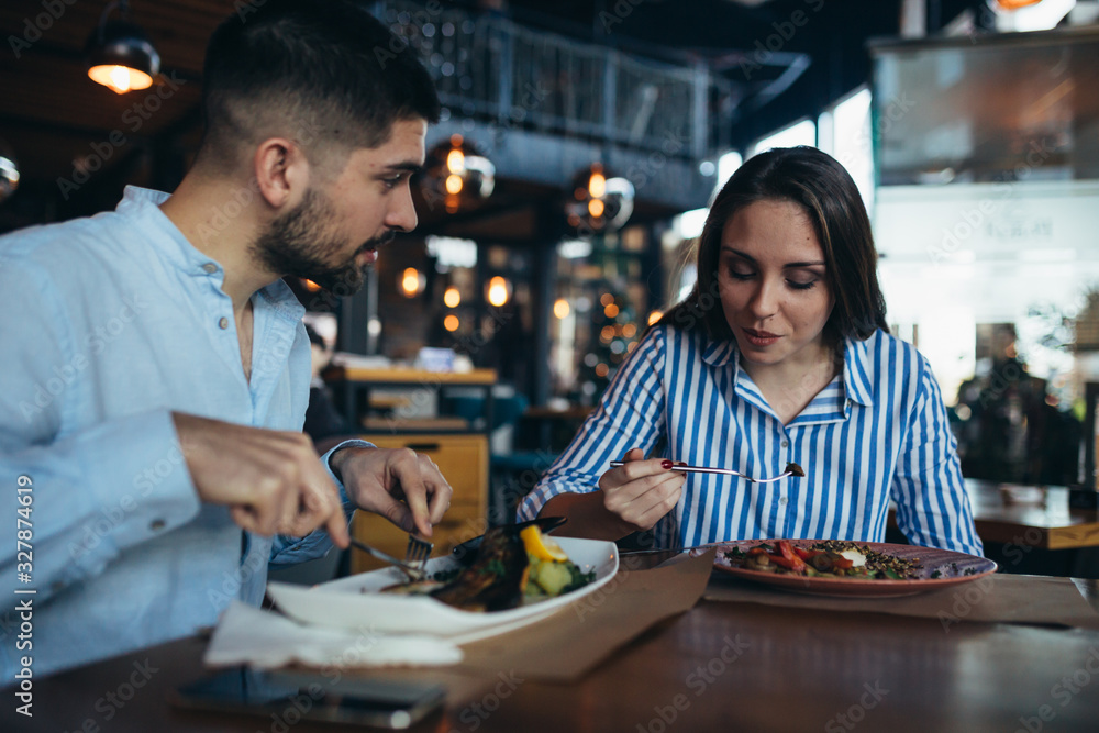 man and woman having lunch in restaurant
