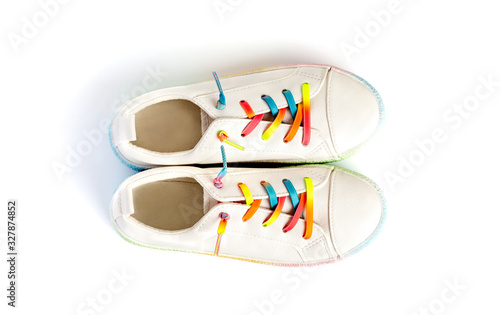 White sneakers with rainbow laces for the child on a isolated backgroun. Top view.