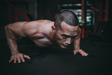 Portrait of asian man big muscle at the gym,Thailand people,Workout for good healthy,Body weight training,Fitness at the gym concept,spiderman plank