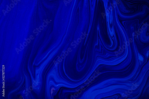 Fluid art texture. Backdrop with abstract swirling paint effect. Liquid acrylic artwork with flows and splashes. Classic blue color of the year 2020. Blue  black and white overflowing colors