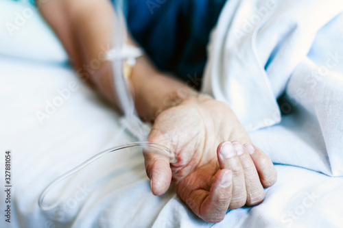 Photos Hand of patient in serious condition is given a medicine through a dropper (healthcare background with an intravenous system)