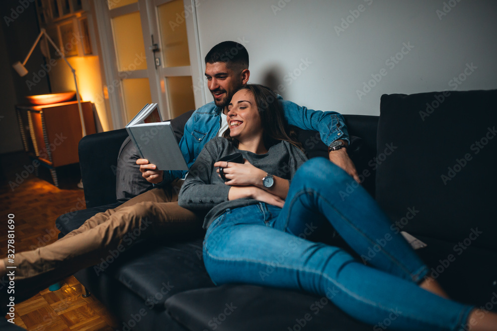 Obraz premium couple reading book relaxing on sofa at home