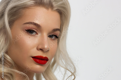 Closeup portrait of a woman with developing straight hair. Sweet tender young girl blonde. Red lipstick, transparent clean skin. Skin care natural cosmetics in the spa salon or cosmetology.
