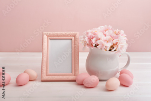 Spring and Easter holiday concept with copy space. Template Easter Greeting Card. Easter eggs and flowers on white background. Easter decoration with eggs. Photo frame and vase with flowers