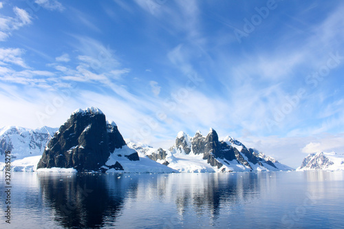 Snow-capped mountains and icy coasts at the entrance to the Lemaire Channel in the Antarctic Peninsula  Antarctica