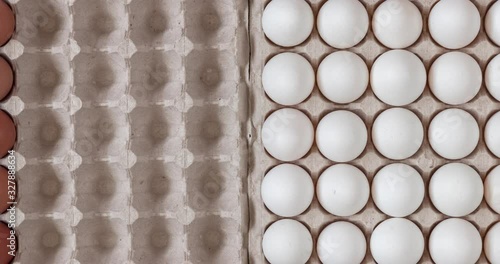 Top view chicken raw eggs of yellow and white color in carton recyclable cardboard box appearing, close-up view on natural pattern, concept of spring and easter