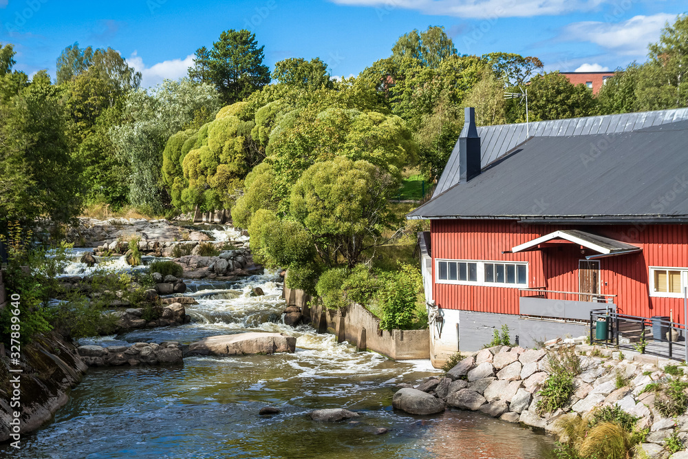 The picturesque view of Vanhakaupunki, the oldest part of Helsinki. The Vantaa river landscape. Red wooden house.