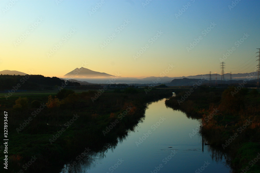A Beautiful Twin Peak Mountain beyond a Quiet Stream at Sunset