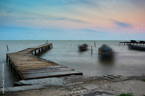 Beautiful morning landscape with boats on the lake at sunrise anchored to the pier, Razelm Lake, Sarichioi, Romania photo