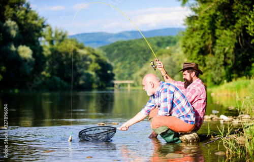 Autumn fishing spinning. Two male friends fishing together. retired dad and mature bearded son. happy fishermen friendship. fly fish hobby of men. retirement fishery. Catching and fishing