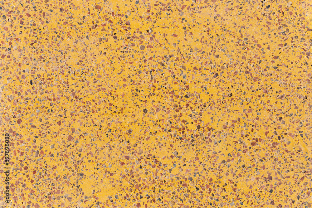 Background of a yellow concrete slab with colored gravel. Artificial flooring, imitation stone. Variegated in composition plane. Background of a yellow concrete slab with colored gravel. Artificial flooring, imitation stone. Variegated in composition plane.
