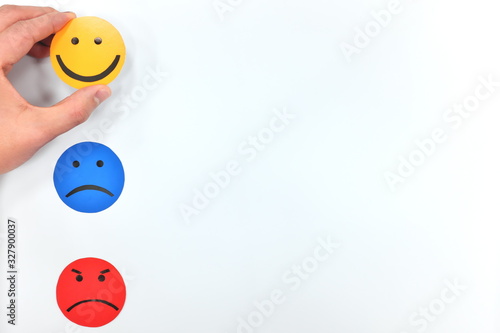 Happy, sad and angry face icons in white background. Hand choosing happiness. Customer satisfaction and feedback concept.