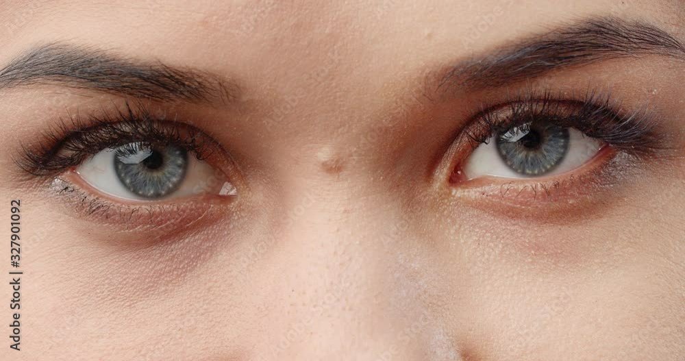 Attractive young blue eyed female looking directly to camera, eyesight care, extreme closeup Attractive young blue eyed female looking directly to camera, eyesight care, extreme closeup