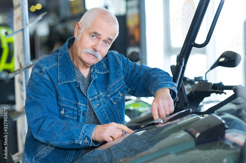 senior man checking motorbike