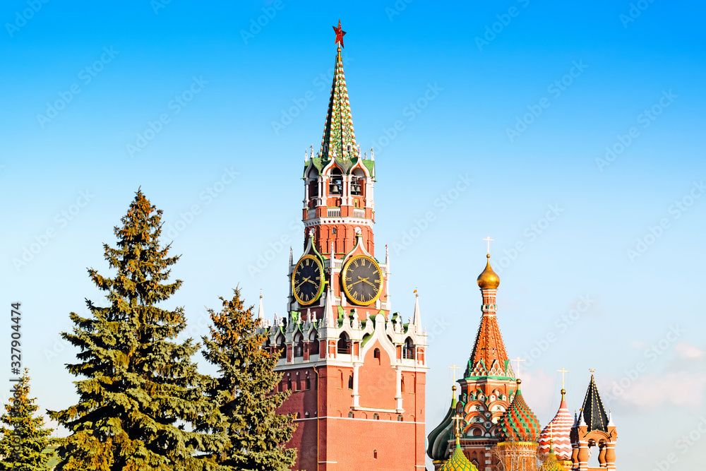 scenic kremlin skyline of moscow city russia with spasskaya clock tower and st. basil cathedral domes against blue sky background. Famous tourist attractions