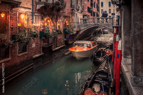 water taxi passes under a bridge on a narrow venice canal © C A Creative