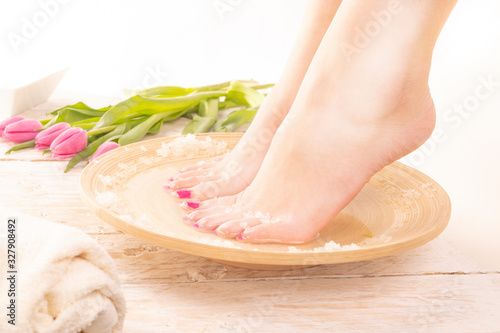 A young woman taking warm footbath with special salts. Home SPA. Woman's Day.