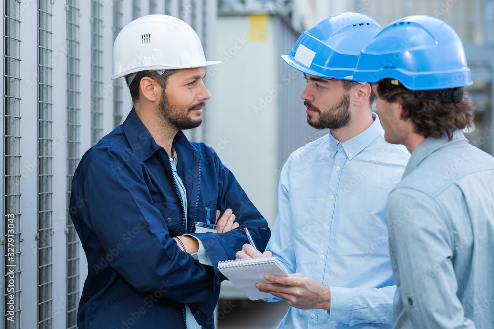 three engineers checking plans with documents at construction site three engineers checking plans with documents at construction site