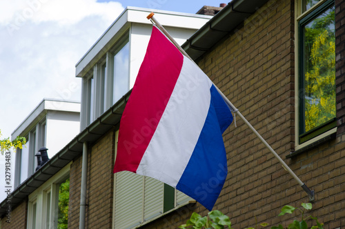 Dutch flag on a facade of a house during a national holiday in the Netherlands