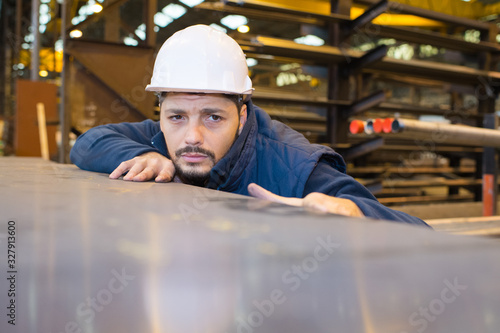 workman looking over the surface of sheet of metal