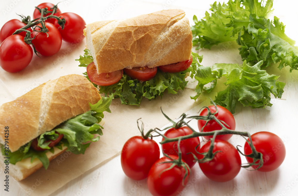 sandwiches with tomatoes, lettuce and cheese on a light background, next to cherry, selective focus sandwiches with tomatoes, lettuce and cheese on a light background, next to cherry, selective focus