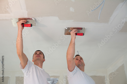 Wallpaper Mural Two construction workers doing a hard finish of a ceiling Torontodigital.ca