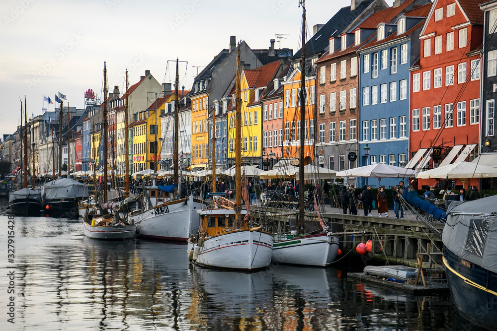 View to boats in front of colourful old houses at Nyhavn harbour canal in Copenhagen, Denmark. February 2020