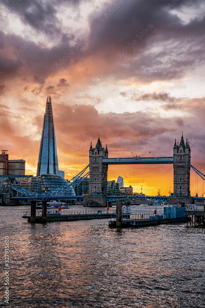 Naklejka premium Die berühmte Tower Brücke in London, beliebte Touristen Attraktion an der Themse, bei Sonnenuntergang mit Wolken und Sonne, Großbritannien