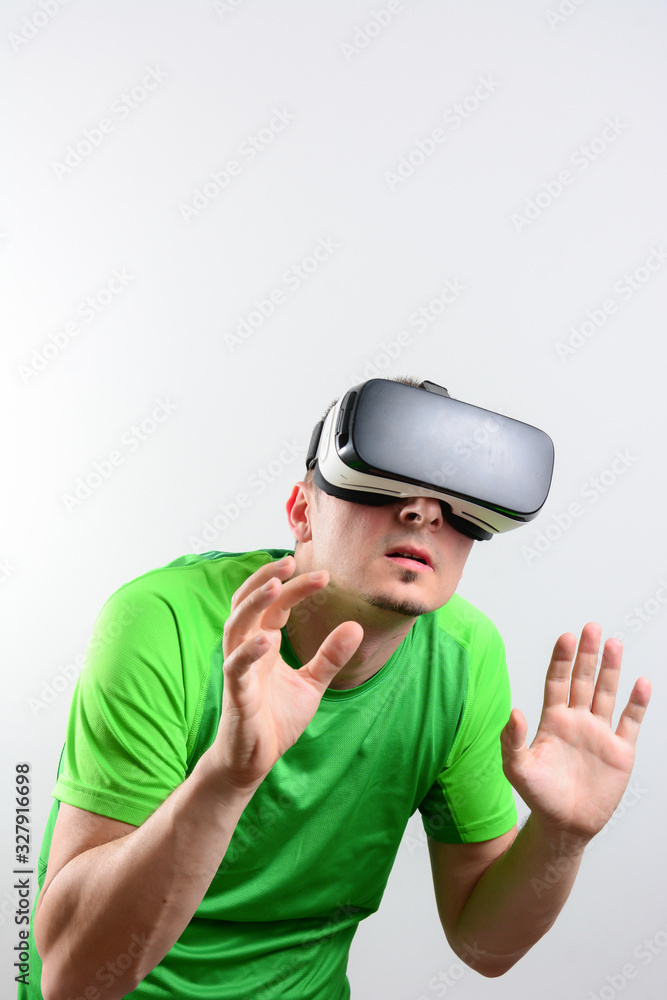 Young handsome bearded man wearing virtual reality goggles in studio on colorful background. Smartphone using with VR headset. Young handsome bearded man wearing virtual reality goggles in studio on colorful background. Smartphone using with VR headset.