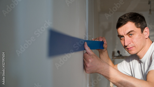 Construction worker preparing wall for painting