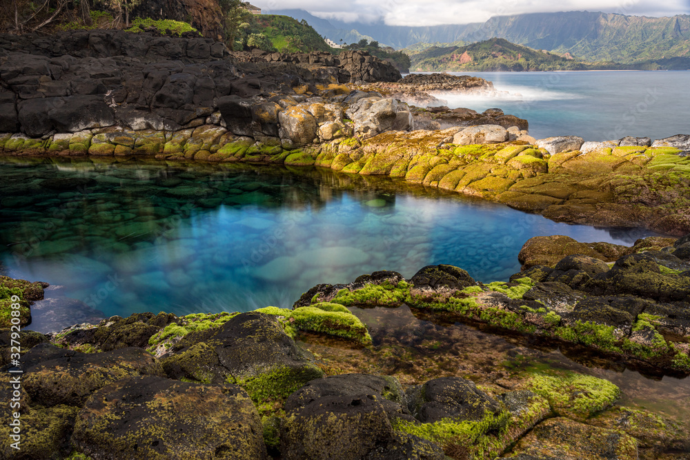 Long exposure of the calm waters of Queen's Bath, a rock pool off Princeville on north shore of Kauai