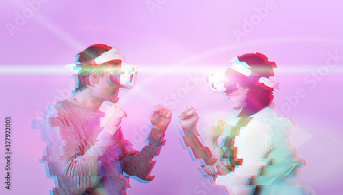 Fototapeta Naklejka Na Ścianę i Meble -  Couple with virtual reality headset are playing game and fighting. Image with glitch effect.