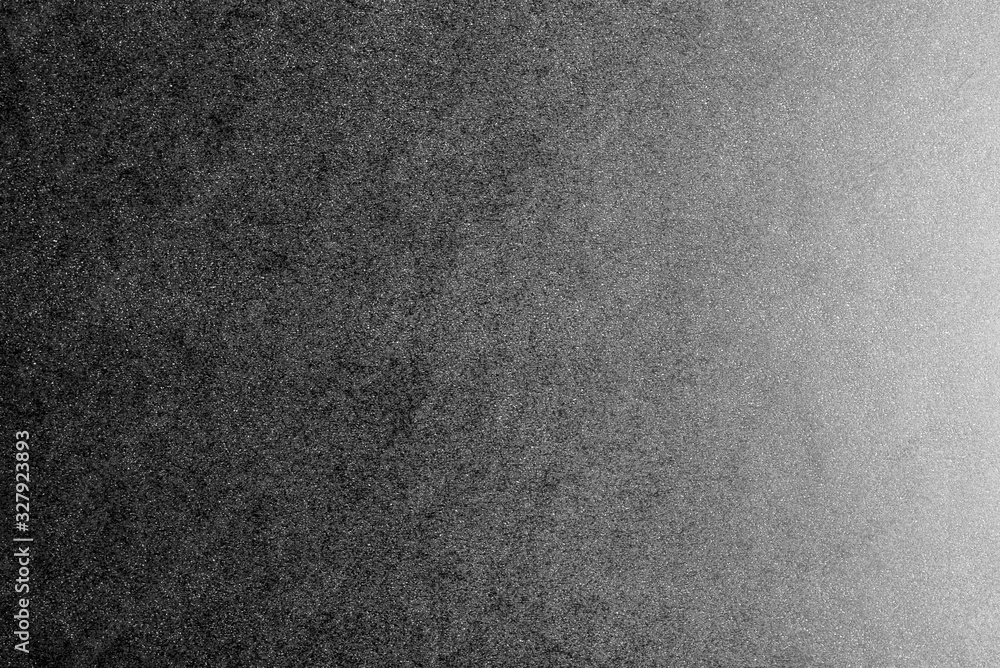 Fototapeta premium Black and white background made of real black paper with white dots, illuminated by a soft light from the right.