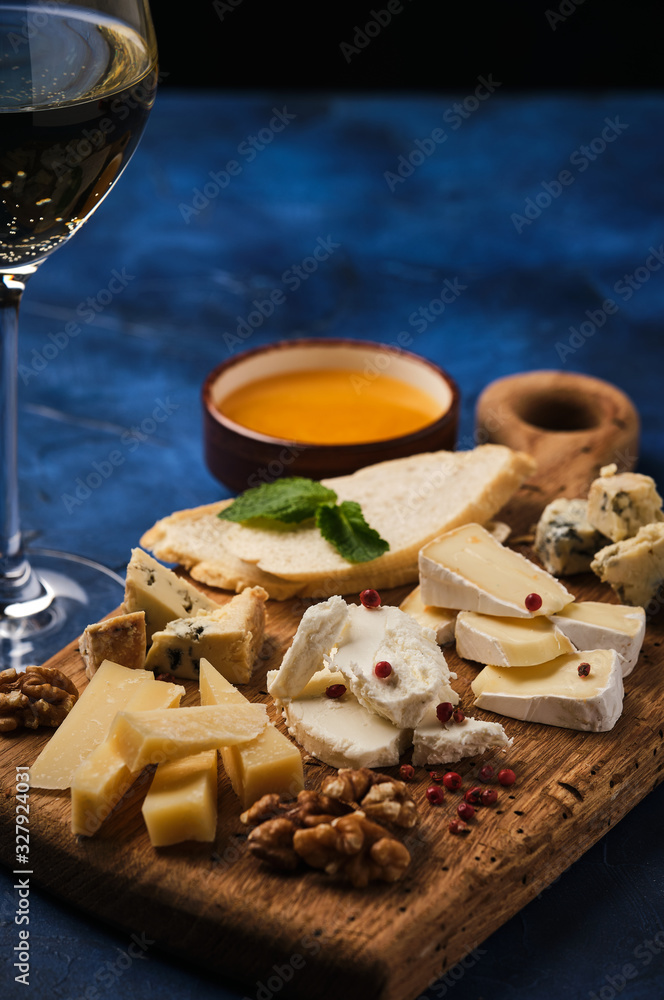 Cheese set with honey and nuts. Assortment of cheeses on a wooden board. Cheese appetizer set. Cheese set with honey and nuts. Assortment of cheeses on a wooden board. Cheese appetizer set.